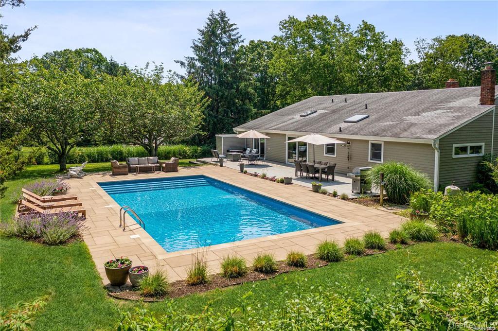 a swimming pool with outdoor seating and yard