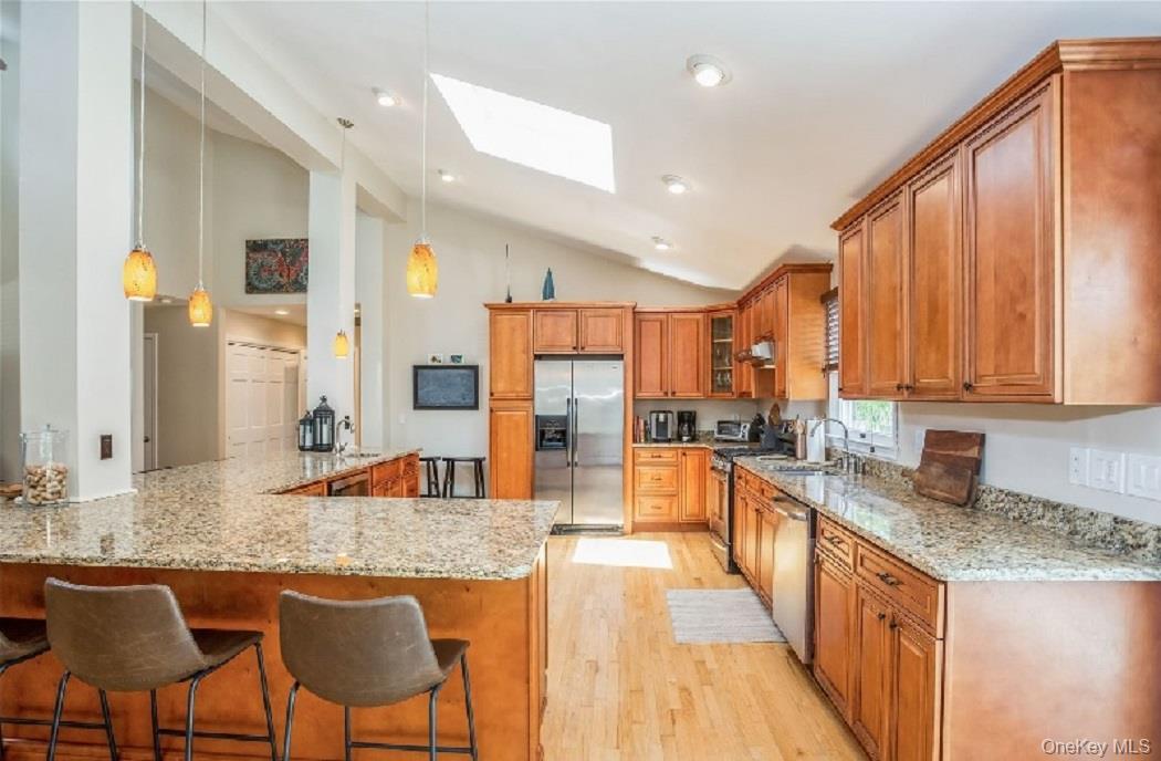 215 Northfield Road Southold, NY 11971 - Photo 9 of 20 a kitchen with stainless steel appliances granite countertop table chairs sink and cabinets