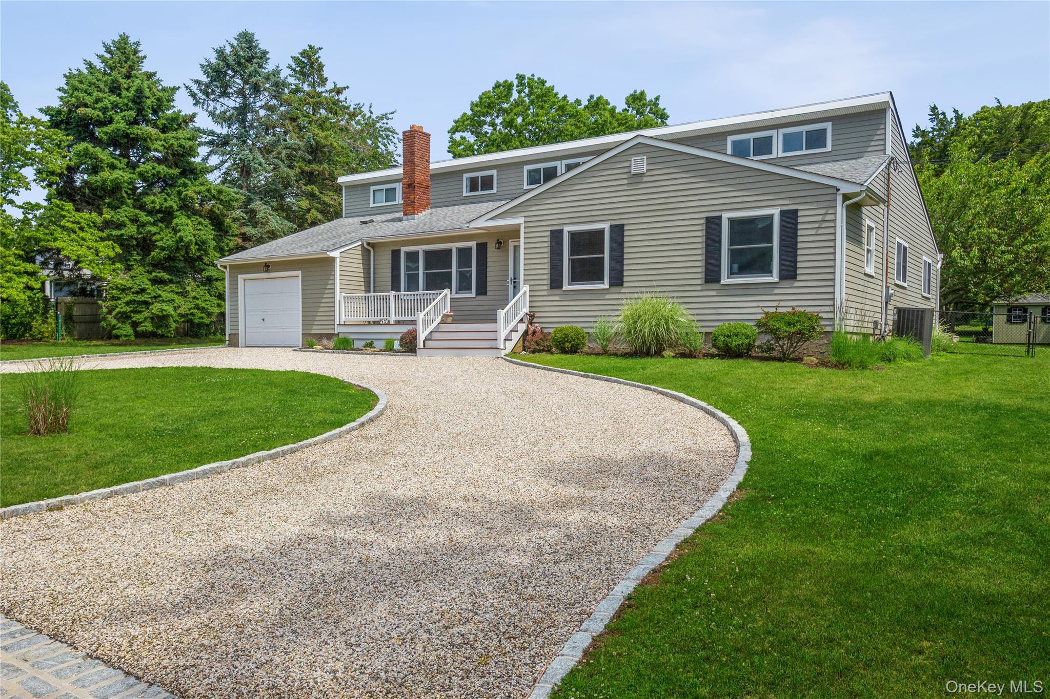215 Northfield Road Southold, NY 11971 - Photo 7 of 20 a front view of a house with a yard and potted plants
