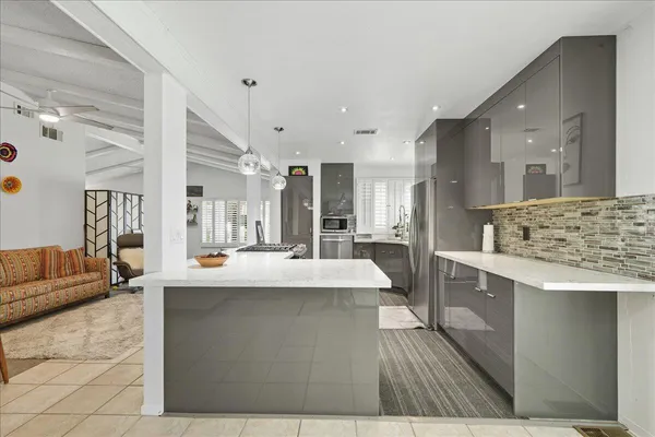 a view of living room kitchen with stainless steel appliances granite countertop furniture and fireplace
