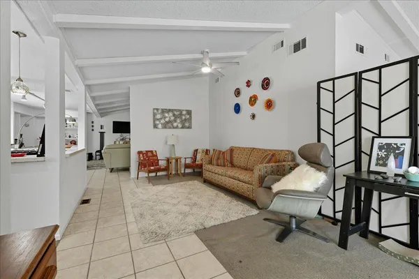 a living room with furniture and a painting on the wall