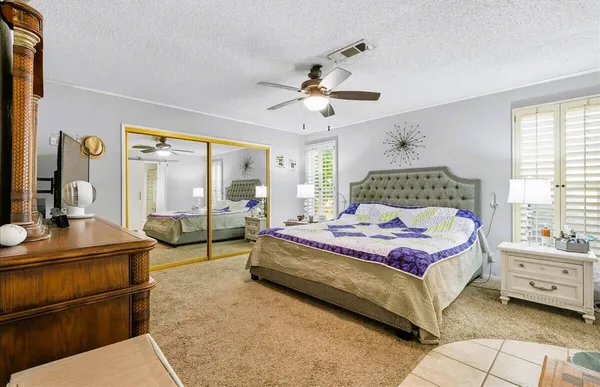 a bedroom with a bed and large windows
