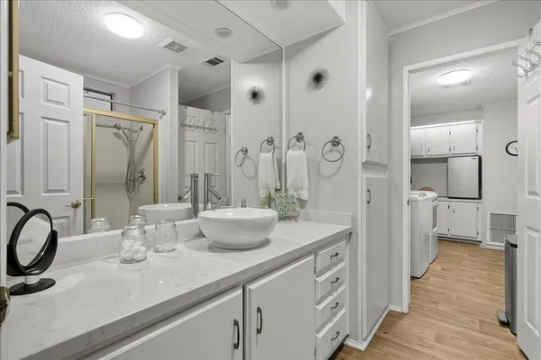 a spacious bathroom with a granite countertop sink mirror and shower