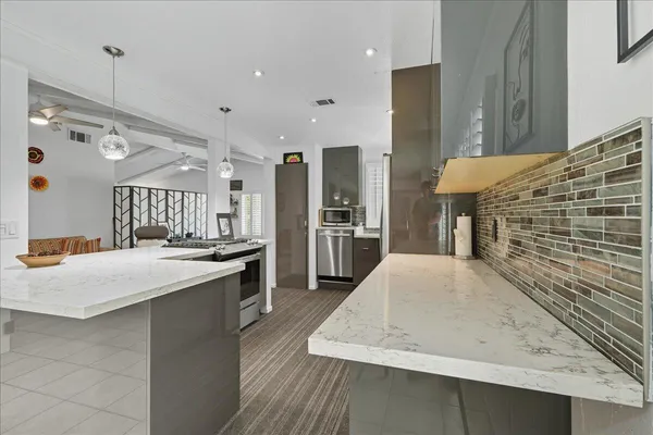 a large kitchen with kitchen island a sink stainless steel appliances and a counter top