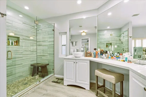 a bathroom with a sink mirror and a shower