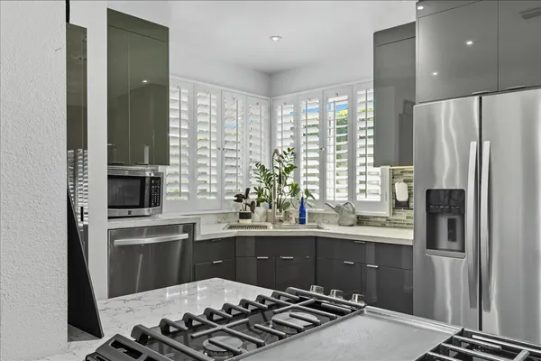 a kitchen with stainless steel appliances a sink stove and refrigerator