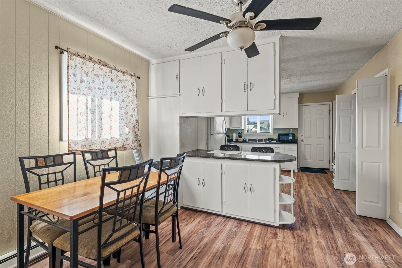 349 27th Avenue Longview, WA 98632 - Photo 9 of 23 a kitchen with stainless steel appliances granite countertop a stove top oven a refrigerator a dining table and chairs with wooden floor