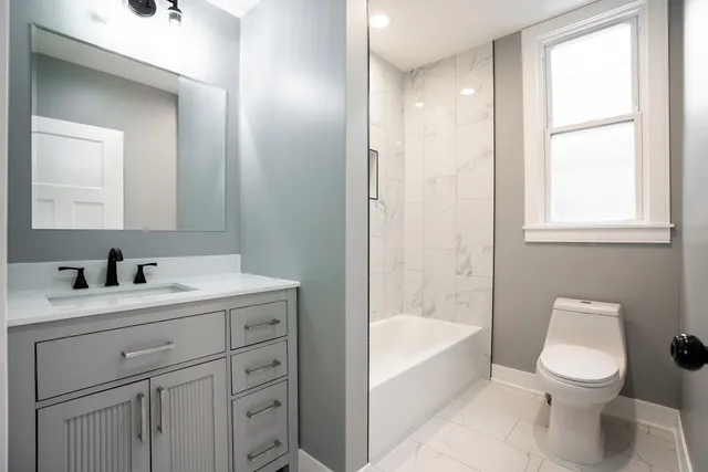 a bathroom with a sink a toilet and shower