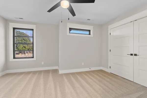 an empty room with a window and a fan