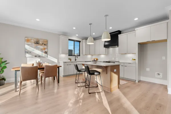 a kitchen with kitchen island granite countertop a sink and a refrigerator