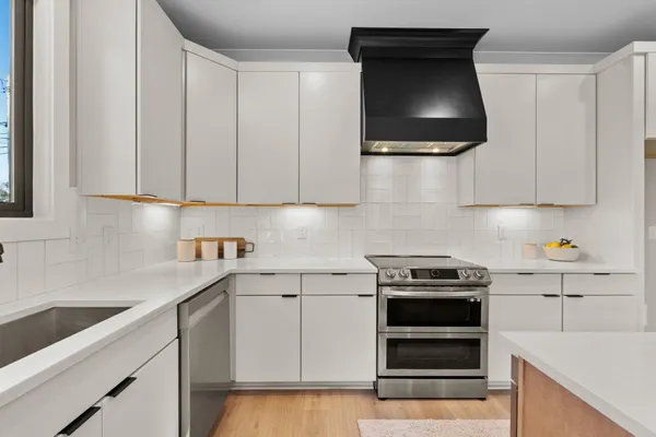 a kitchen with a stove and white cabinets