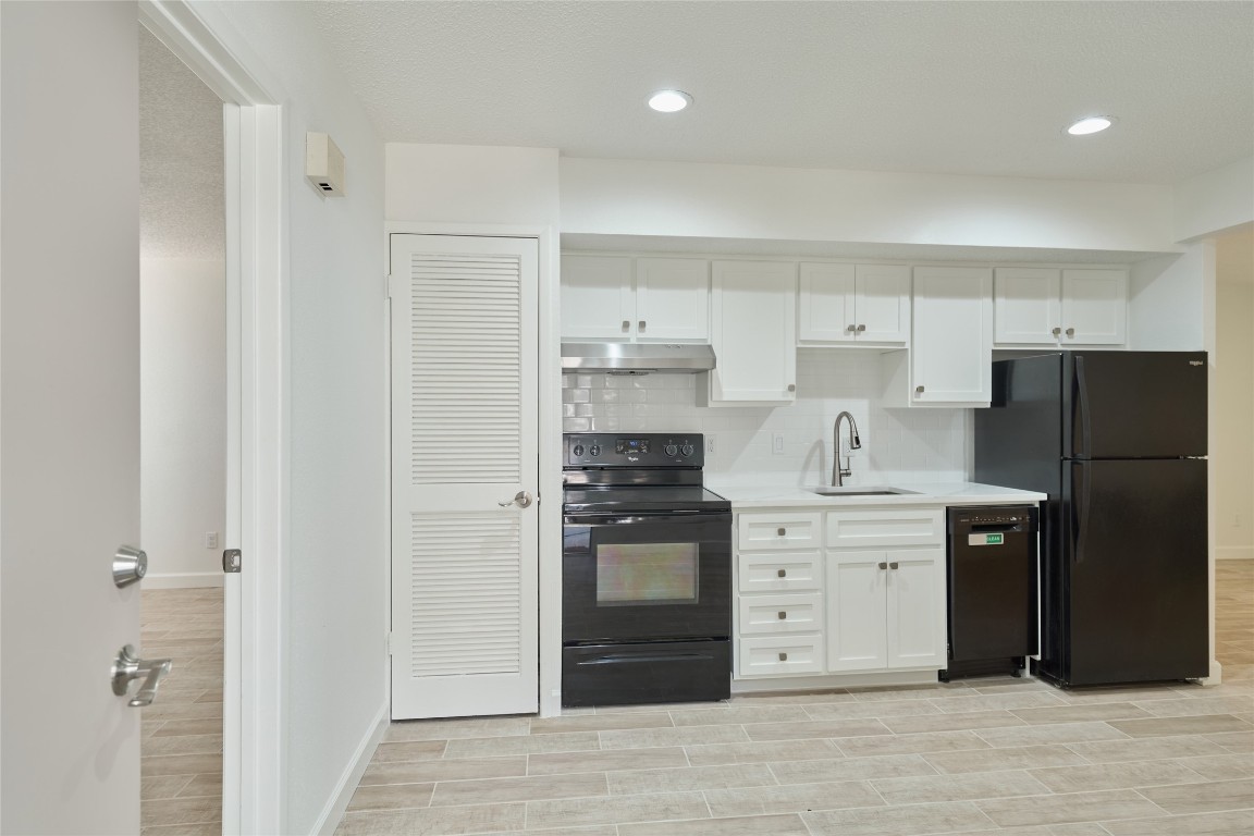 12900 Walden Road, Unit 601F Montgomery, TX 77356 - Photo 10 of 28 a kitchen with a refrigerator stove and white cabinets