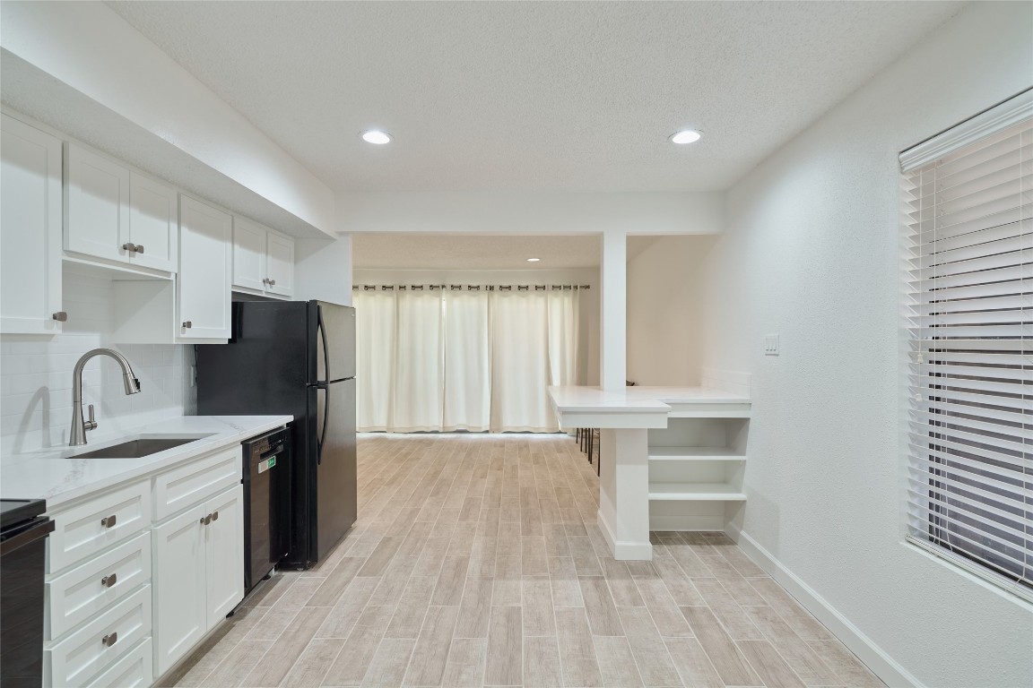 12900 Walden Road, Unit 601F Montgomery, TX 77356 - Photo 8 of 28 a kitchen with granite countertop a refrigerator stove sink and cabinets