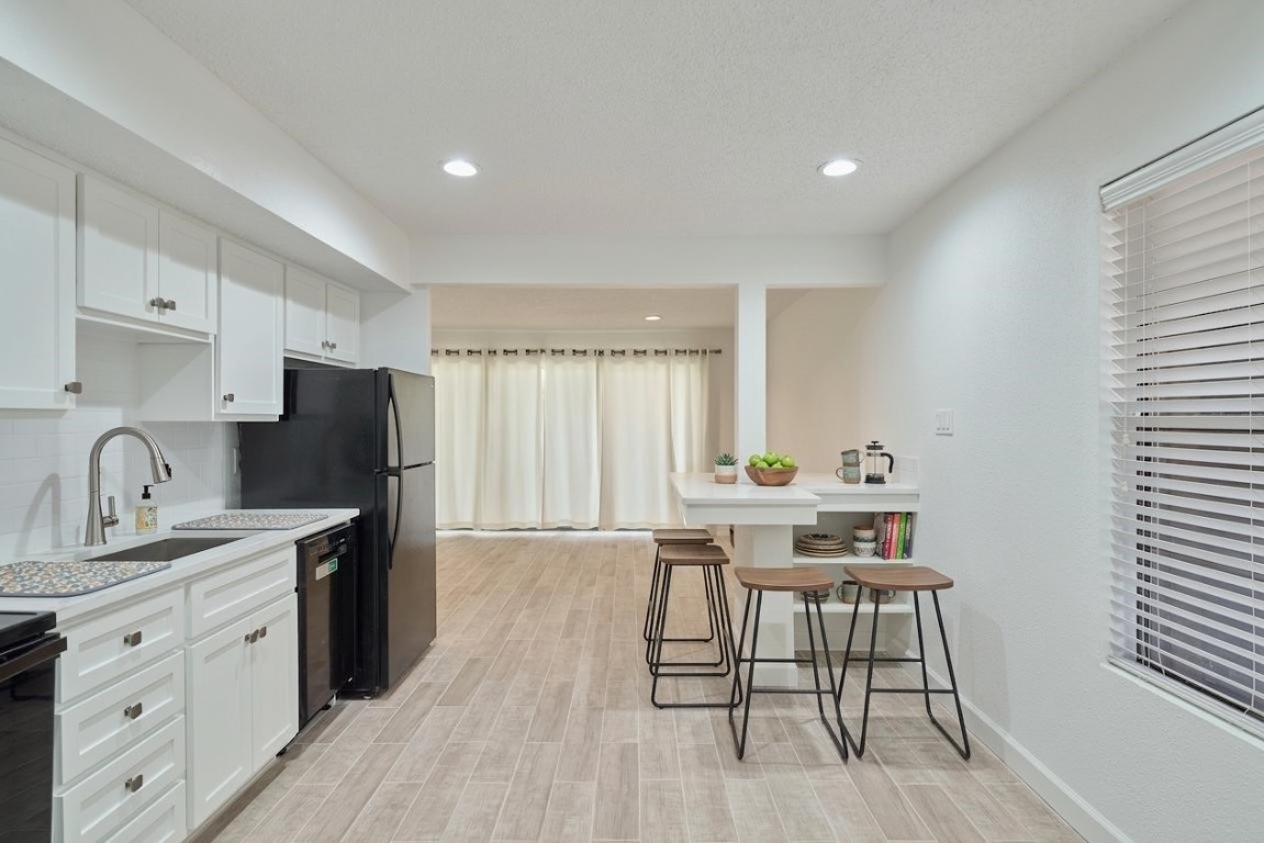 12900 Walden Road, Unit 601F Montgomery, TX 77356 - Photo 9 of 28 a kitchen with stainless steel appliances granite countertop a stove a sink a refrigerator and white cabinets with wooden floor