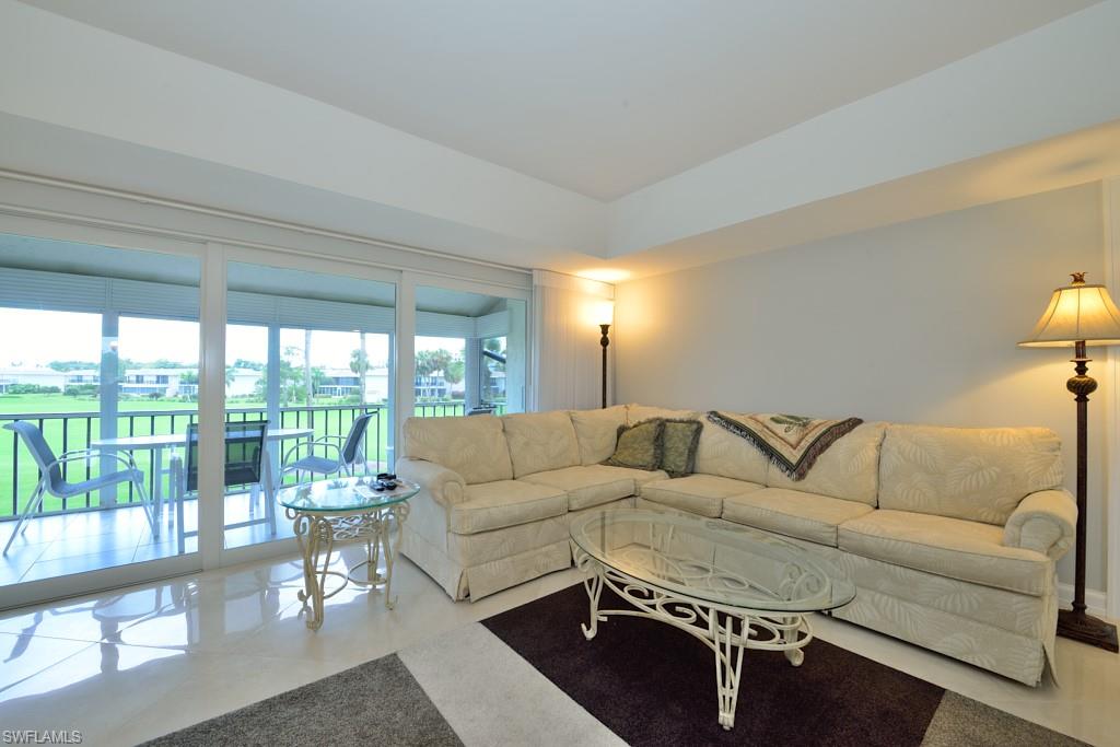 124 Penny Lane, Unit 778 Naples, FL 34112 - Photo 3 of 13 a living room with furniture and a large window