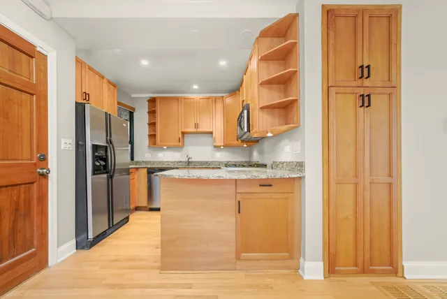 a kitchen with stainless steel appliances granite countertop a refrigerator and a sink