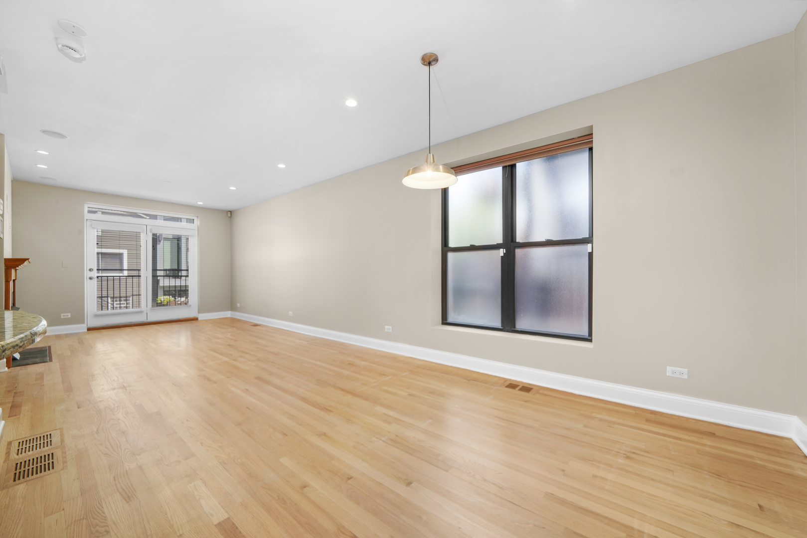 1640 West Ohio Street, Unit 1R Chicago, IL 60622 - Photo 4 of 13 a view of an empty room with a window and wooden floor