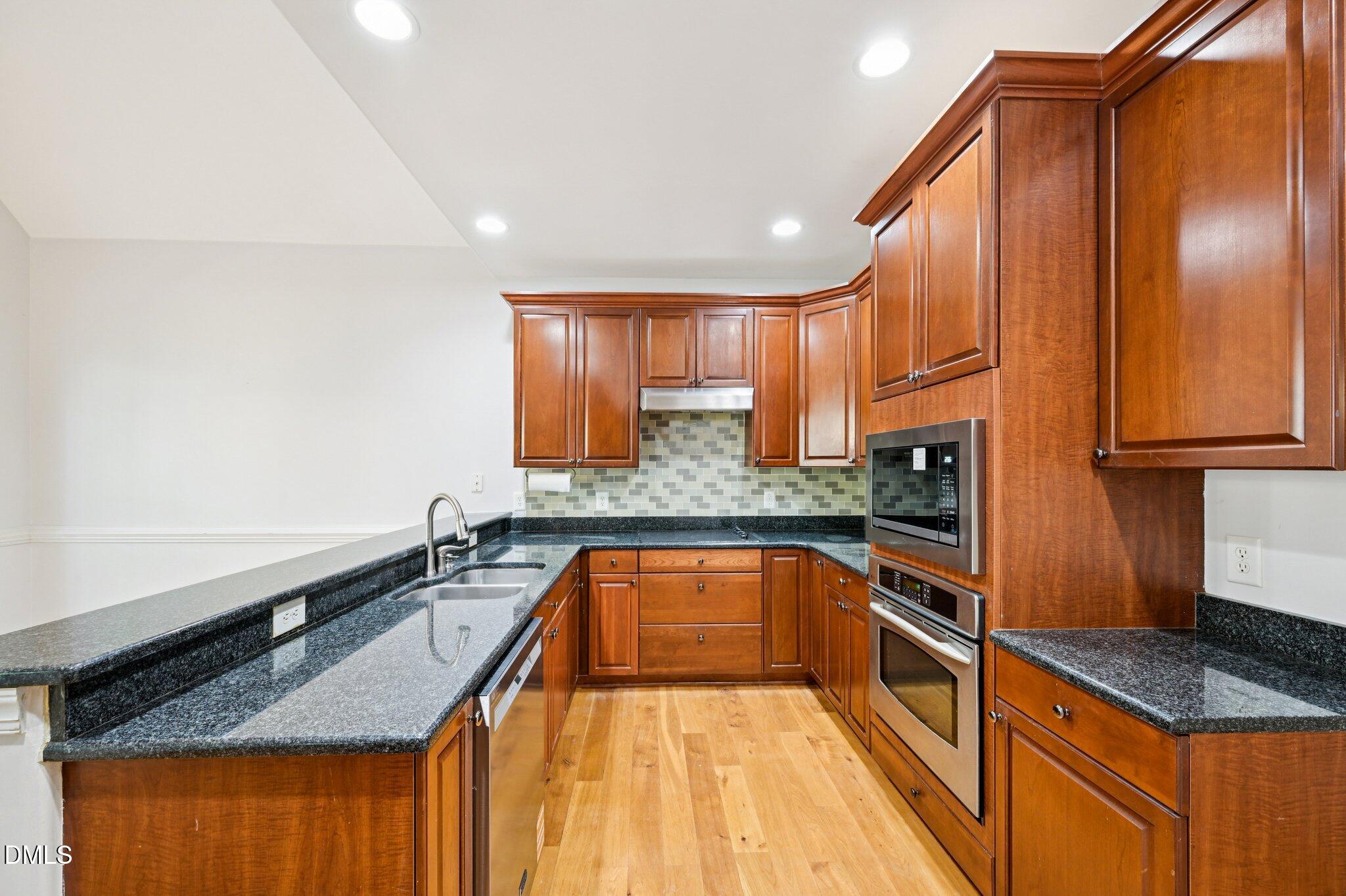 7628 Stony Hill Road Wake Forest, NC 27587 - Photo 12 of 33 a kitchen with granite countertop stainless steel appliances a sink a counter space and a window