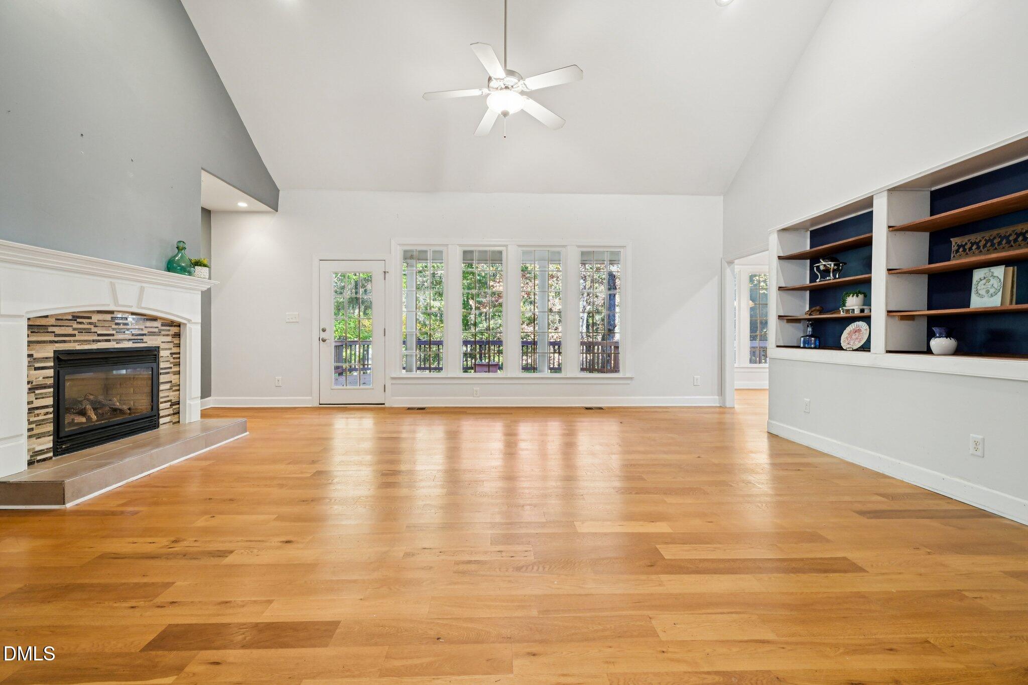 7628 Stony Hill Road Wake Forest, NC 27587 - Photo 7 of 33 wooden floor in an empty room with a fireplace and a window