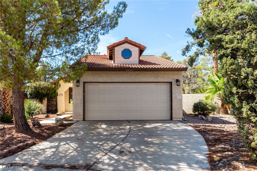 6465 West Plumcrest Road Las Vegas, NV 89108 - Photo 1 of 34 Mediterranean / spanish home featuring a tiled roof, a garage, stucco siding, and concrete driveway