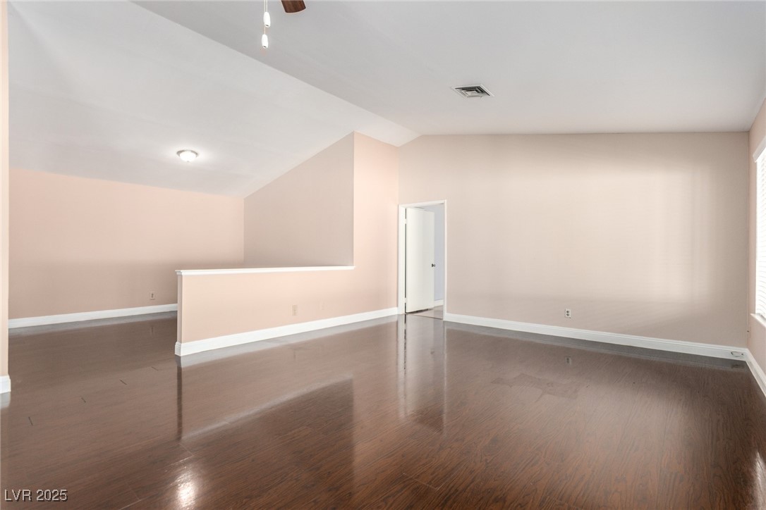 6465 West Plumcrest Road Las Vegas, NV 89108 - Photo 11 of 34 Additional living space with vaulted ceiling, dark wood finished floors, and a ceiling fan