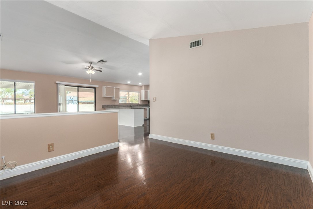 6465 West Plumcrest Road Las Vegas, NV 89108 - Photo 15 of 34 Spare room featuring dark wood-type flooring, vaulted ceiling, ceiling fan, and recessed lighting