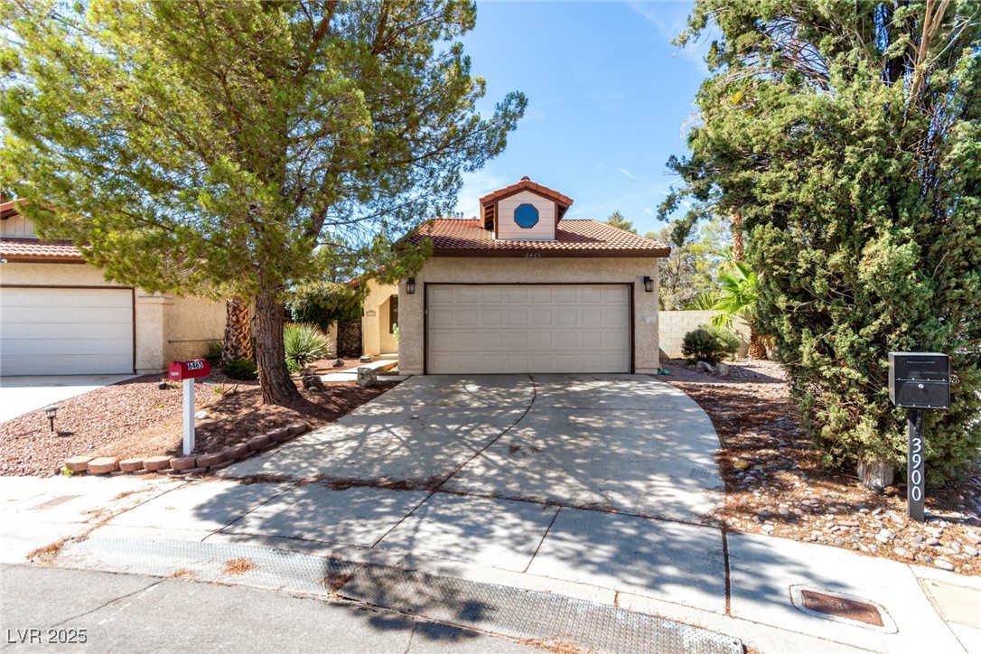 6465 West Plumcrest Road Las Vegas, NV 89108 - Photo 2 of 34 View of front of property featuring a tiled roof, concrete driveway, an attached garage, and stucco siding