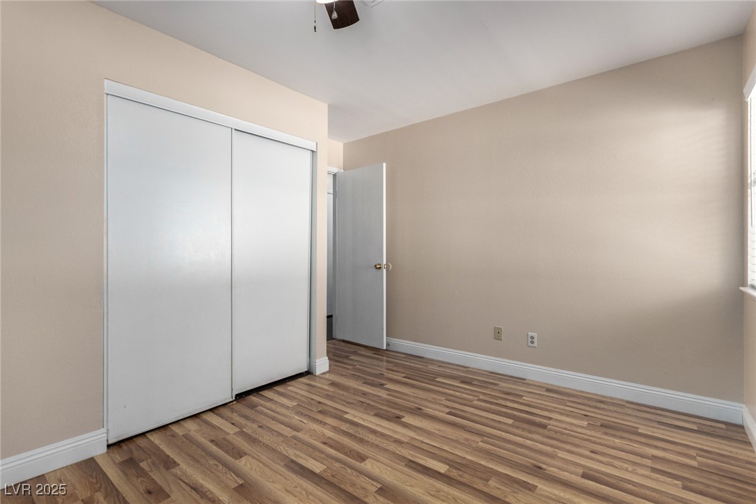 6465 West Plumcrest Road Las Vegas, NV 89108 - Photo 23 of 34 Unfurnished bedroom with wood finished floors, a ceiling fan, and a closet