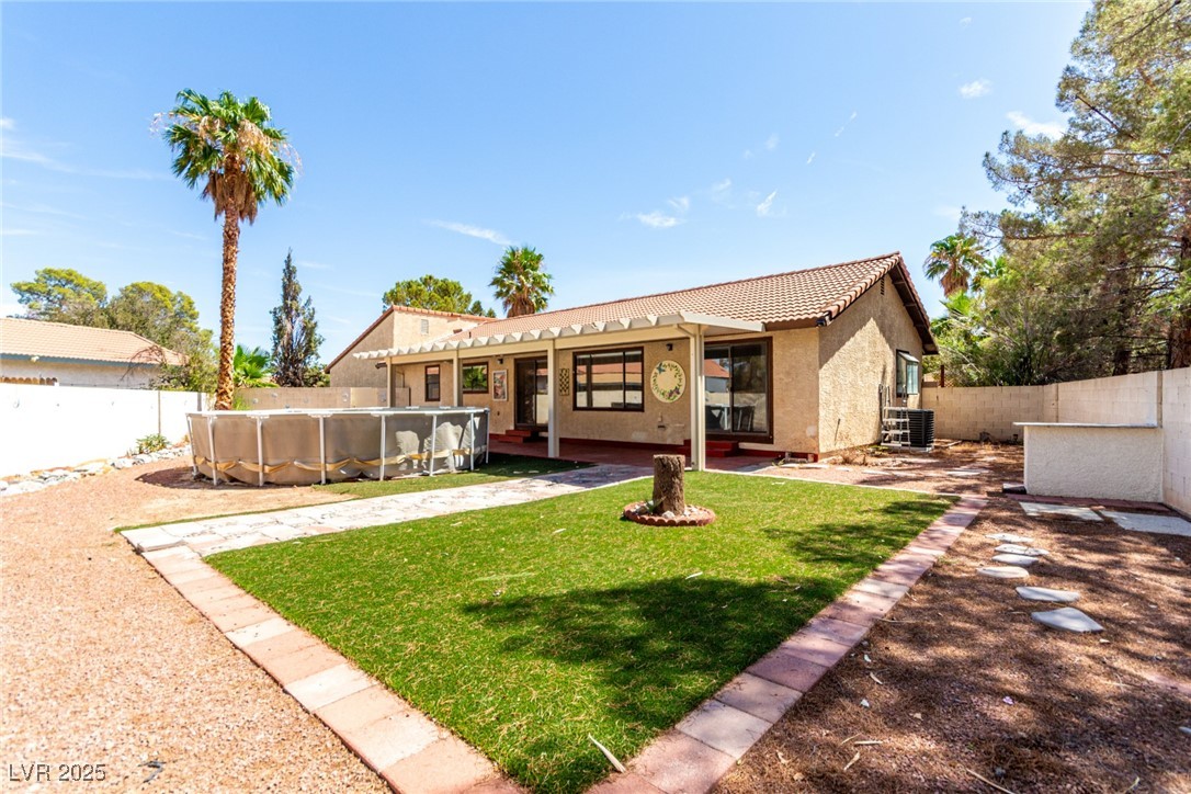 6465 West Plumcrest Road Las Vegas, NV 89108 - Photo 31 of 34 Back of property with a fenced backyard, a tiled roof, and stucco siding
