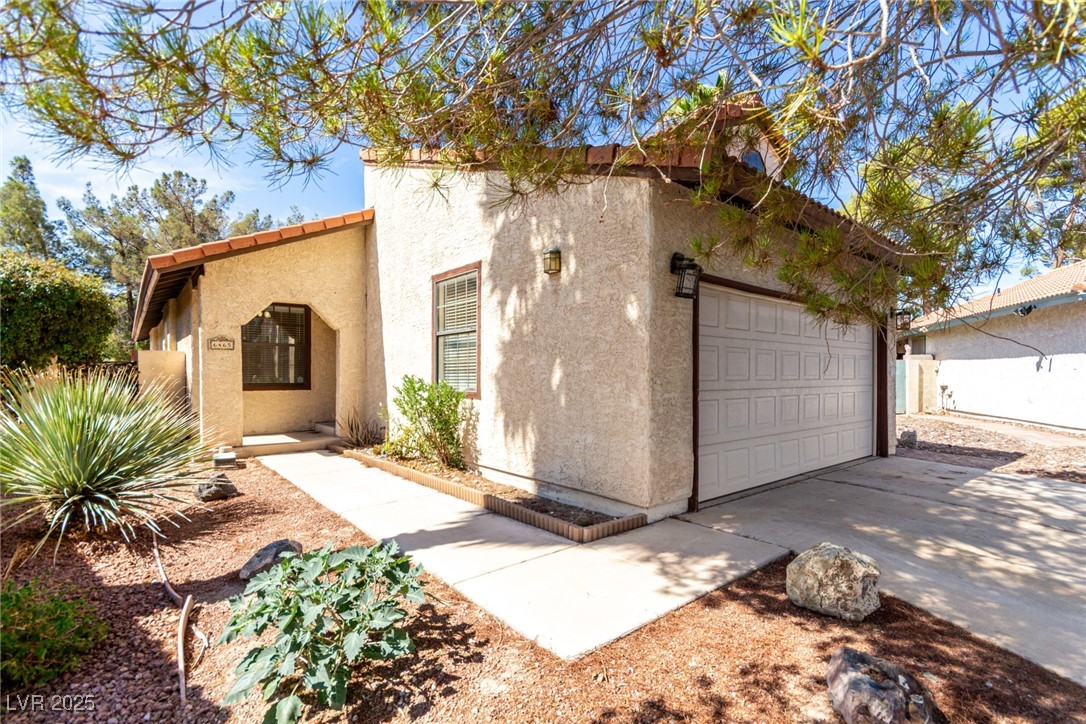 6465 West Plumcrest Road Las Vegas, NV 89108 - Photo 7 of 34 Mediterranean / spanish-style house featuring stucco siding, concrete driveway, and an attached garage