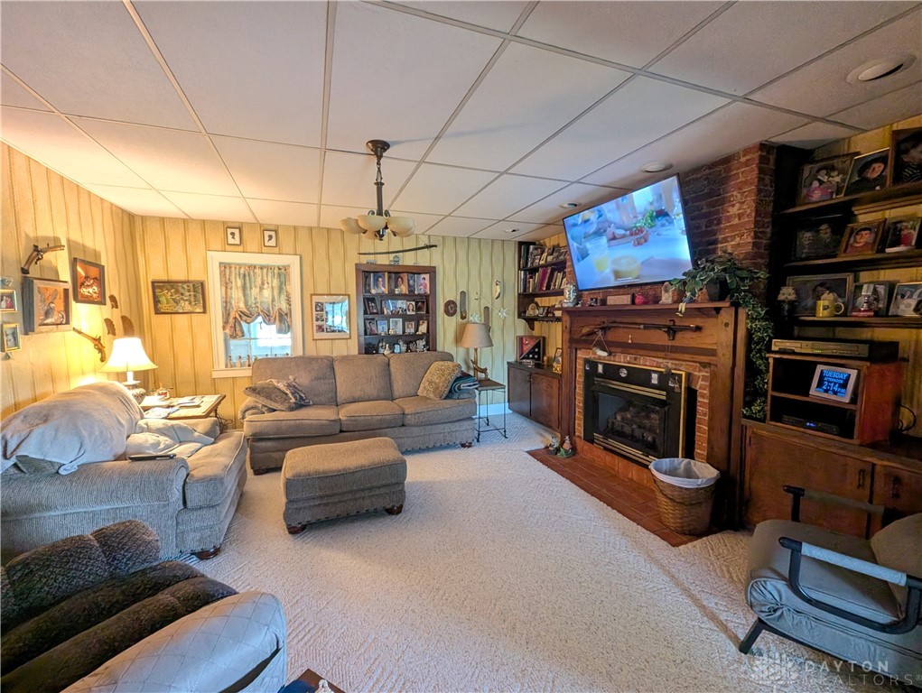 8713 Oakes Road Arcanum, OH 45304 - Photo 21 of 29 This inviting living room features a fireplace, built-in shelving, and soft carpet.