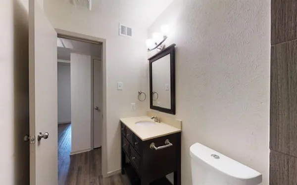 a bathroom with a toilet sink and mirror