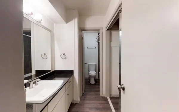 a bathroom with a granite countertop sink and a mirror