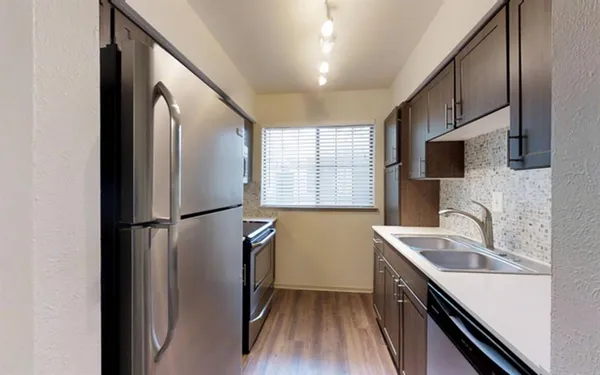 a kitchen with stainless steel appliances a refrigerator sink and microwave