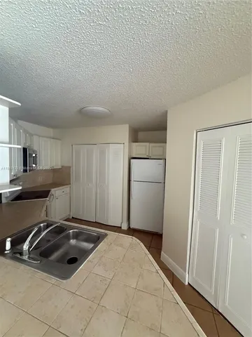 a kitchen with a stove a sink and a refrigerator