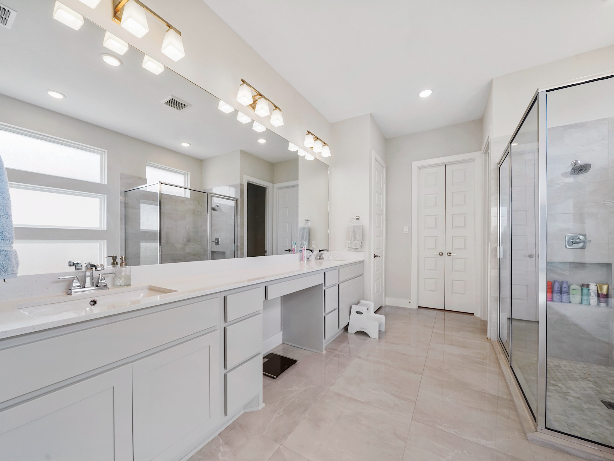5802 Emerald Ranch Lane Fulshear, TX 77441 - Photo 25 of 45 Soft modern finishes and generous space create a refined primary bath retreat complete with extensive vanity storage, makeup counter, and a bright, airy design.