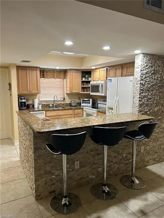 a kitchen with a counter space a sink appliances and cabinets