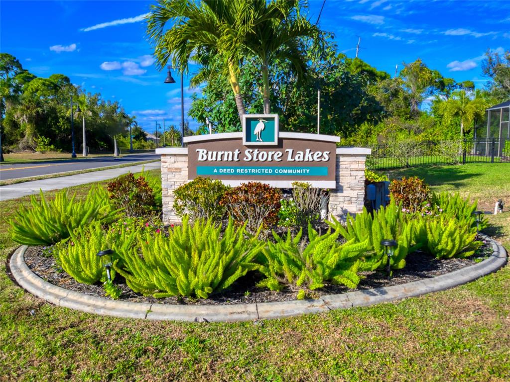 17262 Comingo Lane Punta Gorda, FL 33955 - Photo 2 of 9 a view of a sign in a yard with potted plants