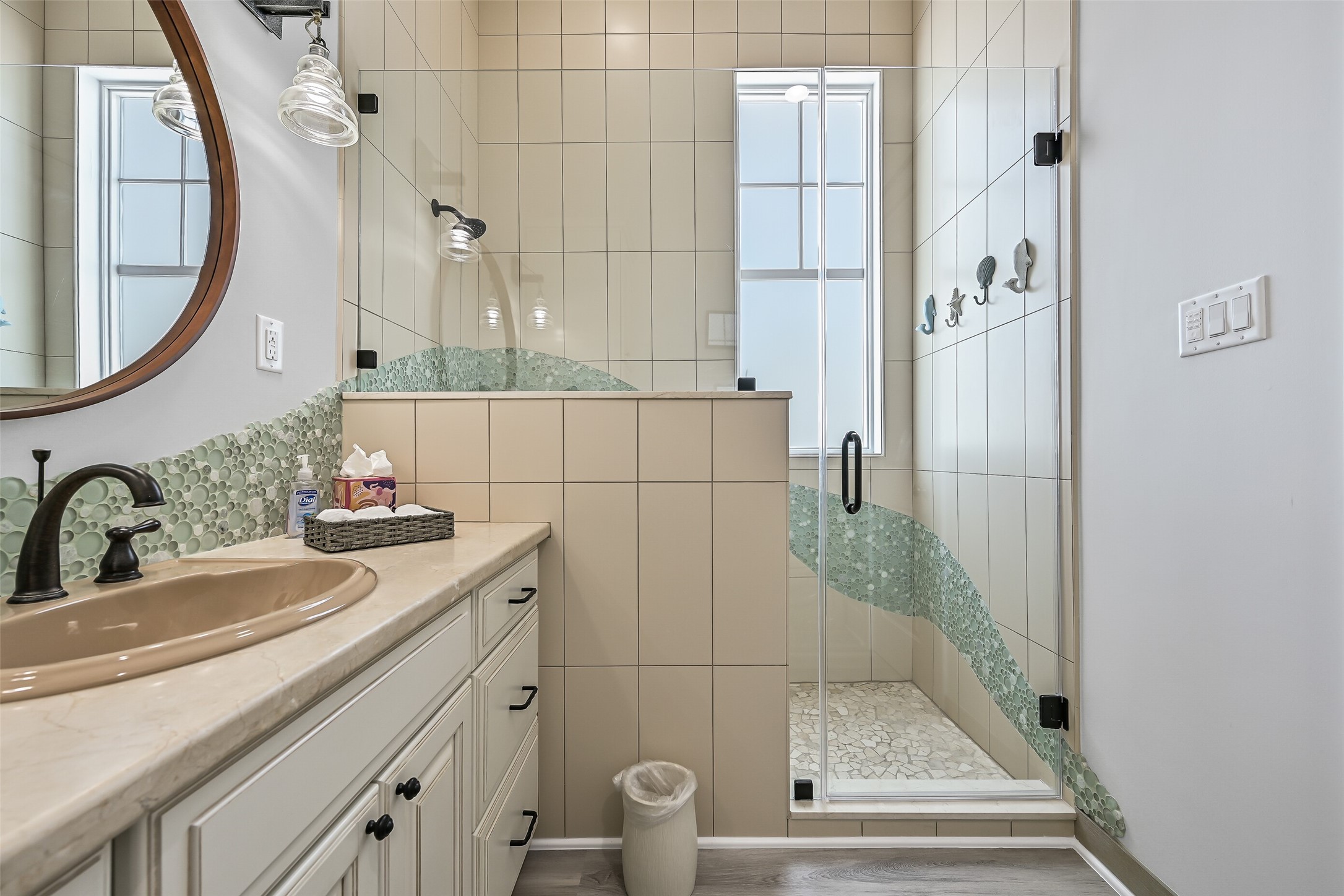 817 Positano Road Galveston, TX 77550 - Photo 35 of 50 A glass-enclosed walk-in shower and distinctive tile accents bring character and style to this well-designed bathroom. Natural light and refined details create a spa-inspired atmosphere that feels both comfortable and sophisticated.