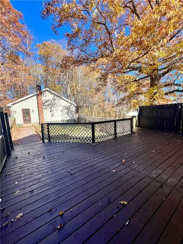 a view of outdoor space with wooden deck and a bench