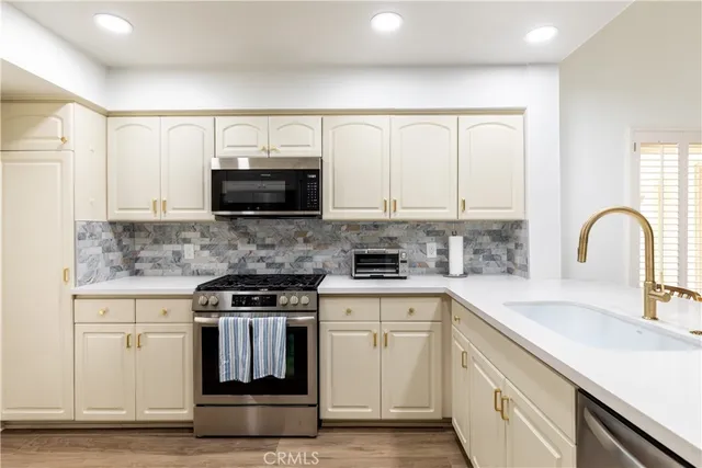 a kitchen with stainless steel appliances granite countertop a stove a sink and a microwave