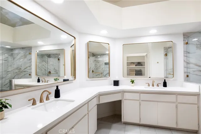 a bathroom with double vanity sinks a large mirror and a bathtub
