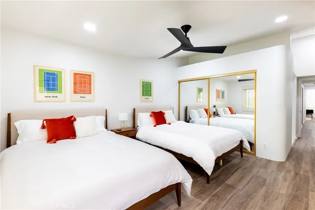 a bedroom with two beds and a large mirror