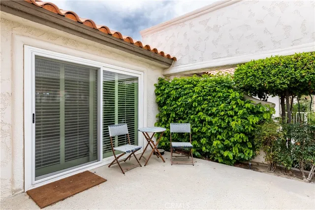 a view of backyard with a chair and potted plants