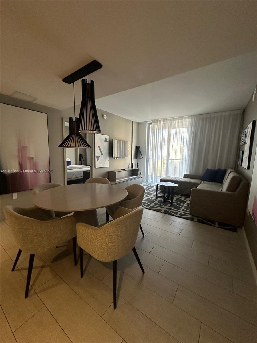 4010 South Ocean Drive, Unit R1707 Hollywood, FL 33019 - Photo 3 of 14 a living room with furniture a rug and a chandelier