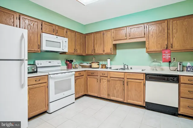 a kitchen with stainless steel appliances granite countertop a refrigerator sink and white cabinets