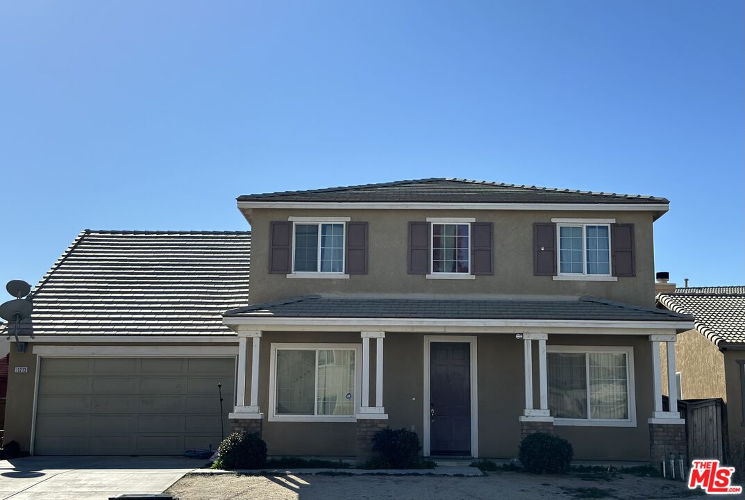 11213 Shanandoah Street Adelanto, CA 92301 - Photo 1 of 1 a front view of a house with a garden