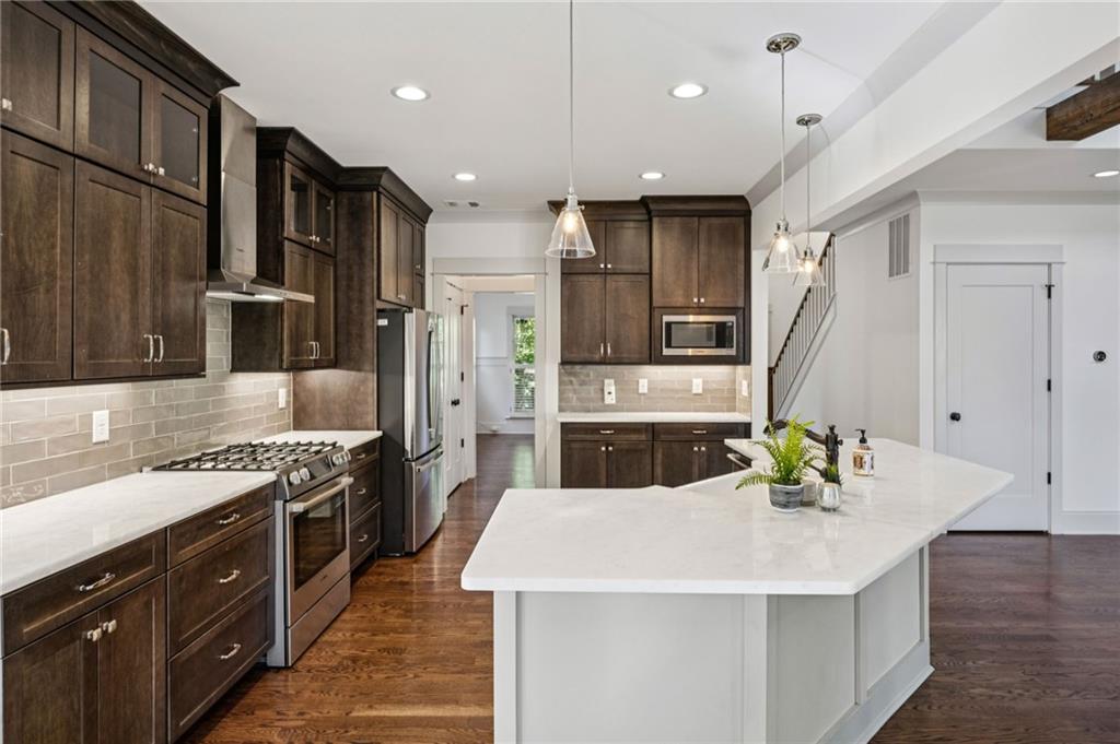213 Ohm Avenue Avondale Estates, GA 30002 - Photo 15 of 43 a kitchen with stainless steel appliances kitchen island a sink stove and refrigerator