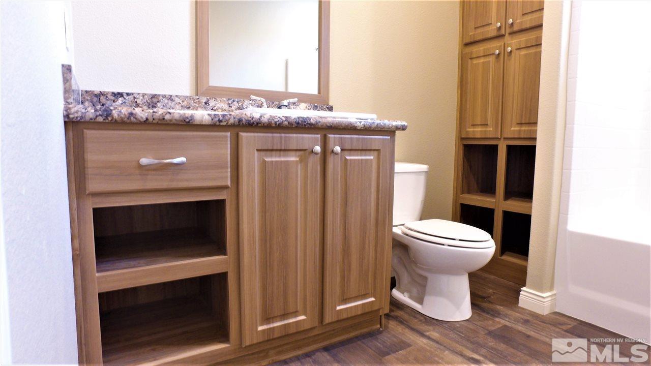 3920 Goldfinch Drive Reno, NV 89508 - Photo 15 of 16 a bathroom with a toilet a sink and mirror