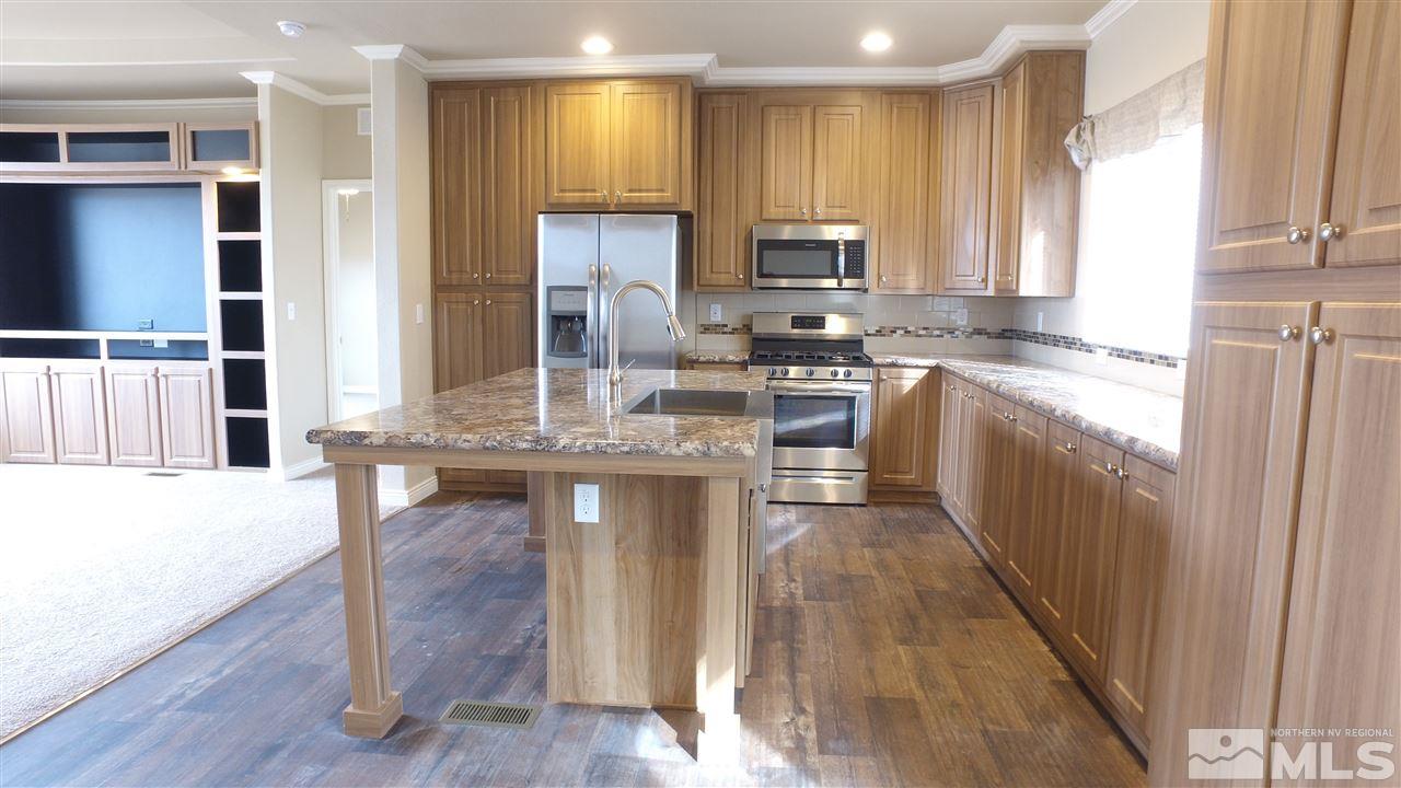 3920 Goldfinch Drive Reno, NV 89508 - Photo 4 of 16 a kitchen with kitchen island granite countertop wooden floors and stainless steel appliances